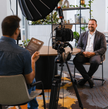 Crew filming a seated interview subject in a Perth office