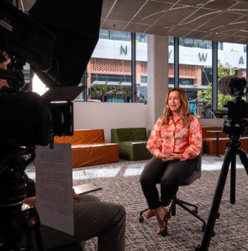 Camera operator filming a presenter in a Perth atrium